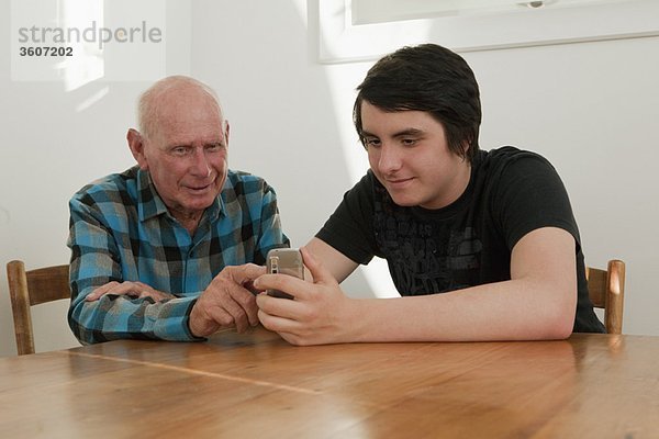 Alter Mann beim Telefonieren mit Enkel