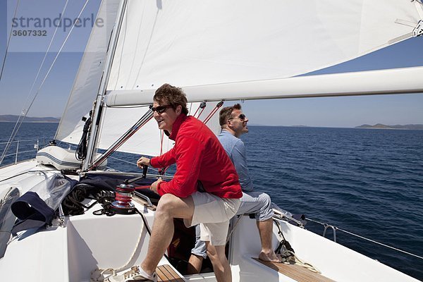 Zwei Männer setzen Segel auf der Yacht