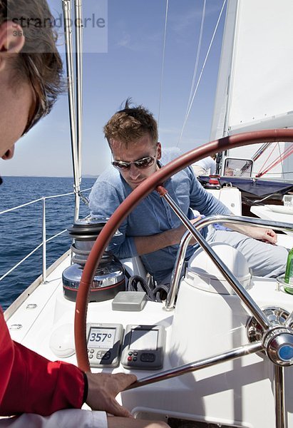 Männer navigieren Yacht