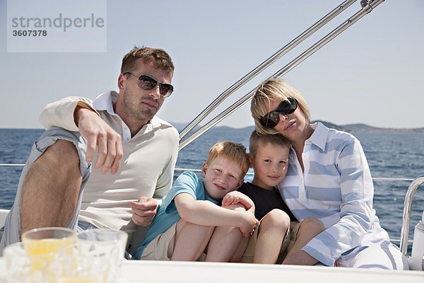 Familie sitzt zusammen auf der Yacht