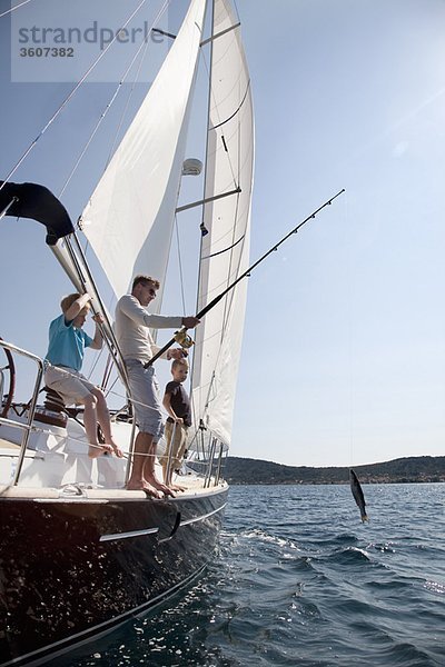 Vater und Söhne fischen auf der Yacht