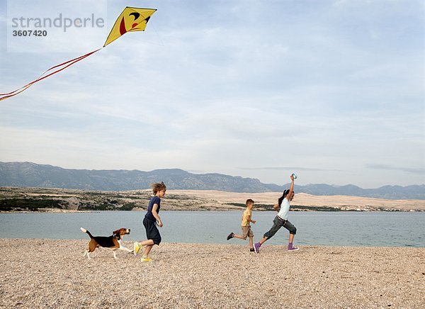Kinder beim Drachenfliegen am Strand