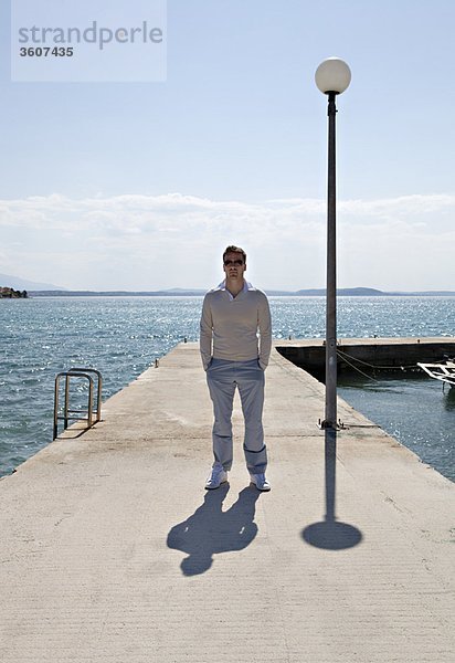 Mann auf dem Pier am Meer stehend