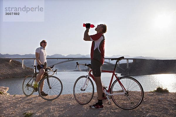 Radfahrer trinken Wasser auf dem Seeweg