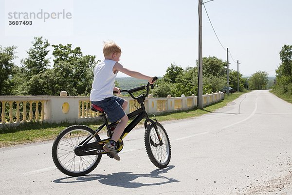 Junge auf dem Fahrrad auf der Landstraße