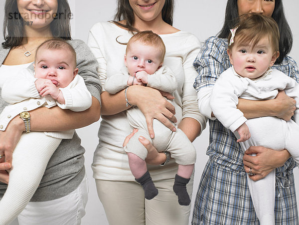 Babys im Arm von Müttern