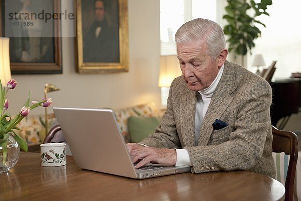 Älterer Mann  der am Computer arbeitet