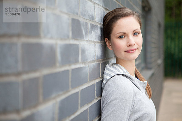 Junge Frau an der Wand