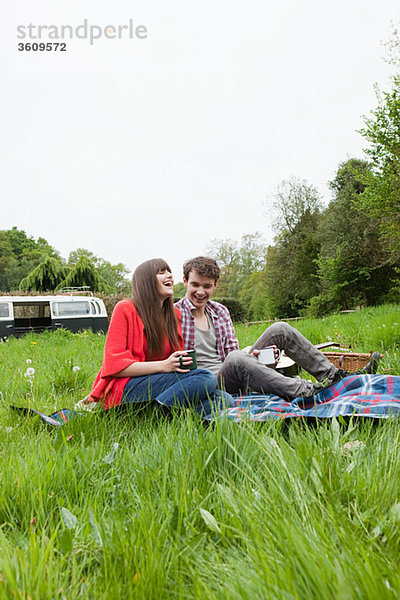 Junges Paar auf einer Decke in einem Feld