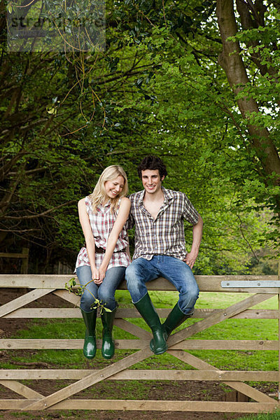 Junges Paar auf dem Tor sitzend