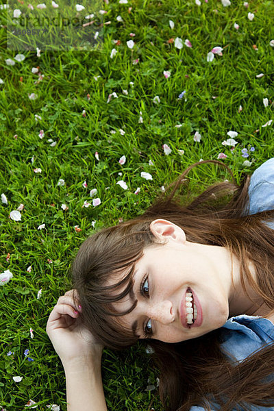 Junge Frau auf Gras liegend