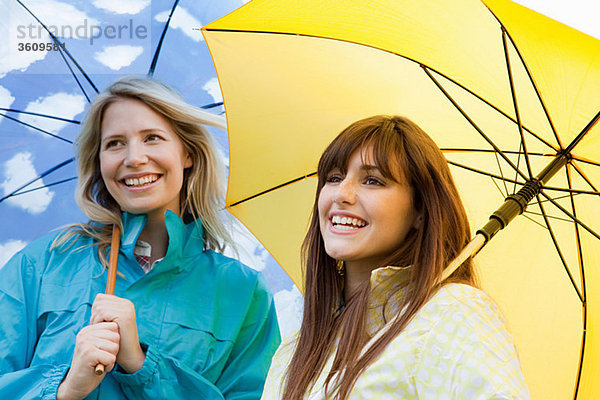 Zwei junge Frauen mit Regenschirmen