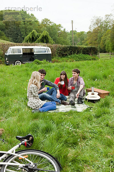 Freunde  die mit dem Wohnmobil im Feld sitzen