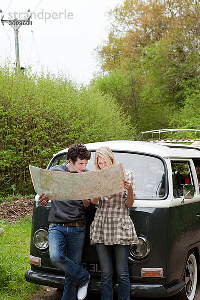 Junges Paar mit dem Wohnmobil auf der Karte