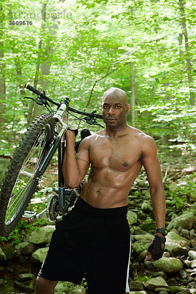 Radfahrer mit Fahrrad im Wald