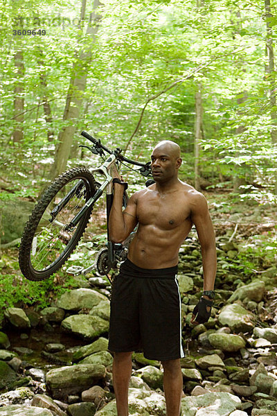 Radfahrer mit Fahrrad im Wald