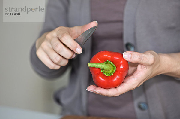 Frau schneidet eine Paprika in der Küche  close-up