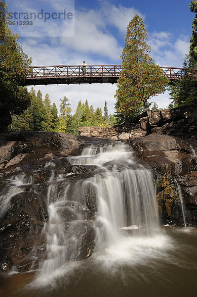 Herr  hölzerne Fuß Brücke  Fifth Falls  Wasserfall  Gooseberry Falls State Park  North Shore  Minnesota  USA