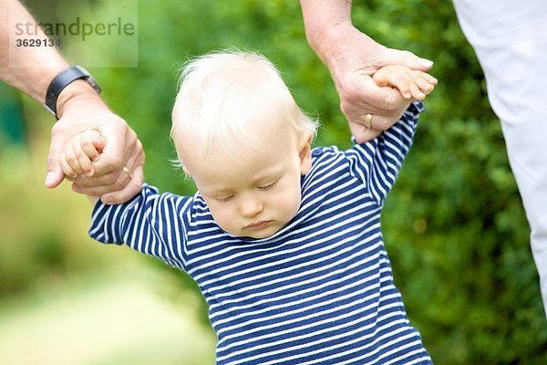 Großeltern gehen Hand in Hand mit Kleinkind