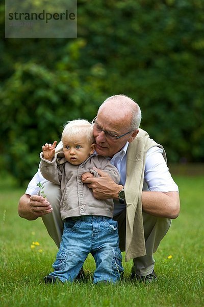 Großvater und Kleinkind auf einer Wiese