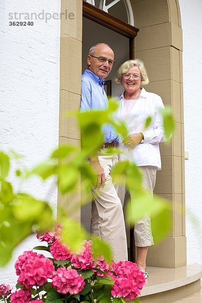Glückliches Seniorenpaar an der Eingangstür