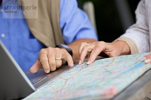 Seniorenpaar mit Laptop und Straßenkarte  close-up