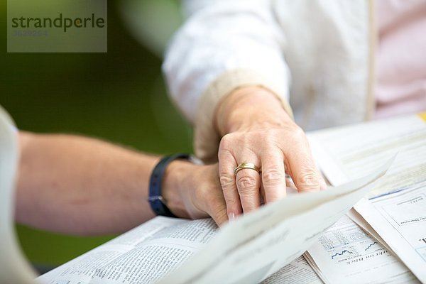 Seniorenpaar liest Hand in Hand Zeitung  close-up