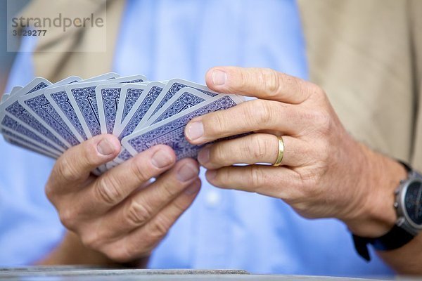 Senior spielt Karten  close-up