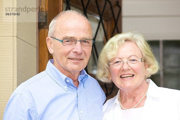 Glückliches Seniorenpaar vor ihrer Haustür  Portrait