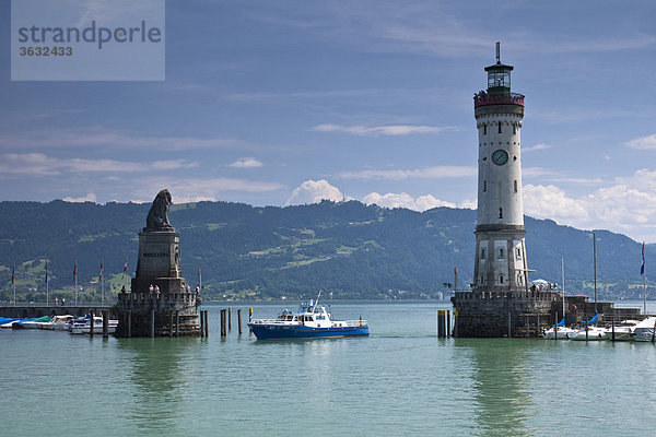 Hafeneinfahrt von Lindau am Bodensee mit dem Bayrischen Löwen und dem Leuchtturm mit einem Boot der Wasserschutzpolizei  Blickrichtung Bregenz mit seinem Hausberg Pfänder  Bayern  Deutschland  Europa