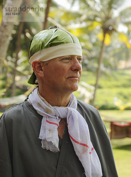Mann mit Bananenblatt auf Kopf  Ayurveda-Behandlung  Bethsaida Hermitage  Kerala  Indien  Asien