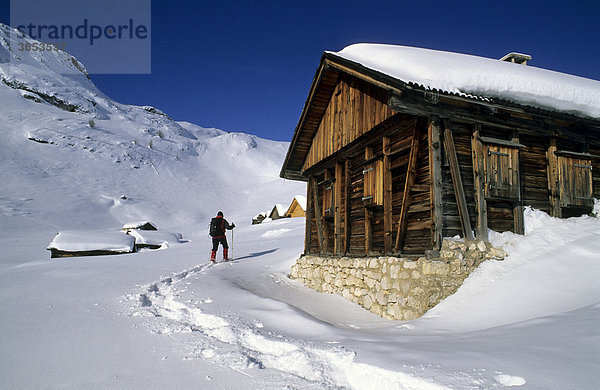 Schneeschuhgeherin zwischen Almhütten  Sennes-Alm  Dolomiten  Italien  Europa