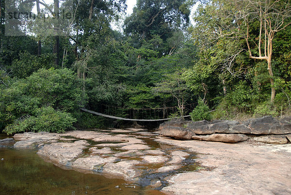 Hängebrücke über Bach im Urwald  felsiges Bachbett  Phou Khao Khouay National Protected Area  Provinz Borikhamxai  Laos  Südostasien  Asien