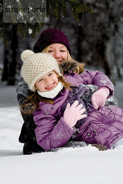 Zwei Mädchen spielen im Schnee