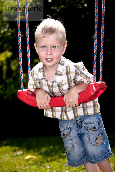Junge spielt auf dem Spielplatz