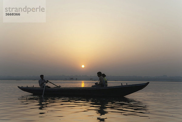 Paar auf Boot blickt in Sonnenaufgang  Ganges  Varanasi  Indien  Asien
