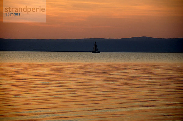 Sonnenuntergang Farbenspiel auf dem See mit Segelboot Podersdorf am Neusiedler See Burgenland Österreich