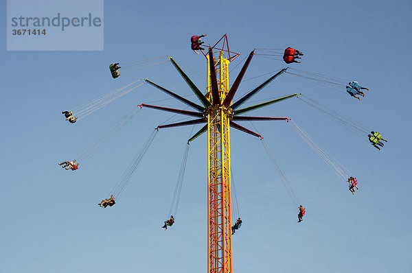 Menschen fliegen weit oben im Kreis neues Kettenkarussell Oktoberfest München