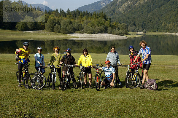 Gruppe Mountainbiker mit ihren Bikes am Bergsee Lödensee bei Reit im Winkl Oberbayern