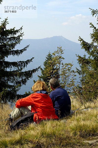 Paar macht eine Wanderpause im Gras mit Blick auf den Großen Arber vom Großen Falkenstein Bayerischer Wald Niederbayern