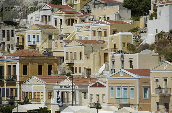 Blick auf die farbenfrohen ockerfarbenen Häuser der Insel Symi Griechenland