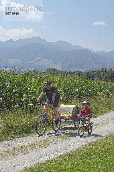 Im Inntal südlich von Rosenheim Oberbayern Vater radelt mit seinem Kind
