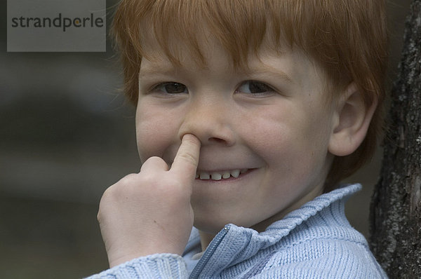 Kleiner Junge 4 vier Jahre mit dem Finger in der Nase