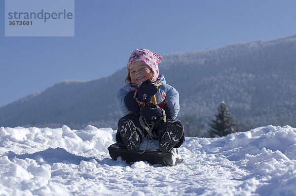 Kind im Winter beim Schlitten fahren