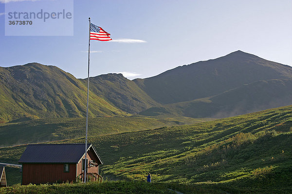 Berghütte und amerikanische Flagge am Hatcher Pass Alaska USA