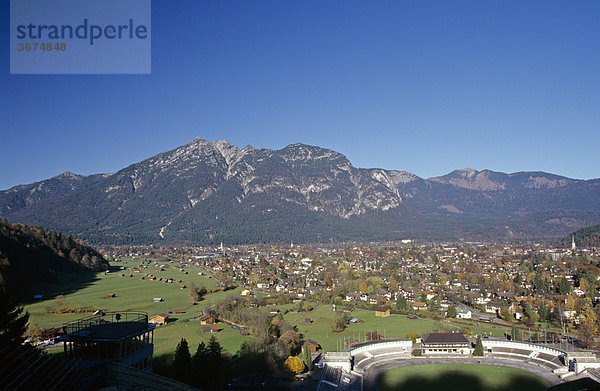 Teil des Schisprung Stadions und Stadtansicht von Garmisch Partenkirchen vor dem Ammergebirge in Bayern Deutschland