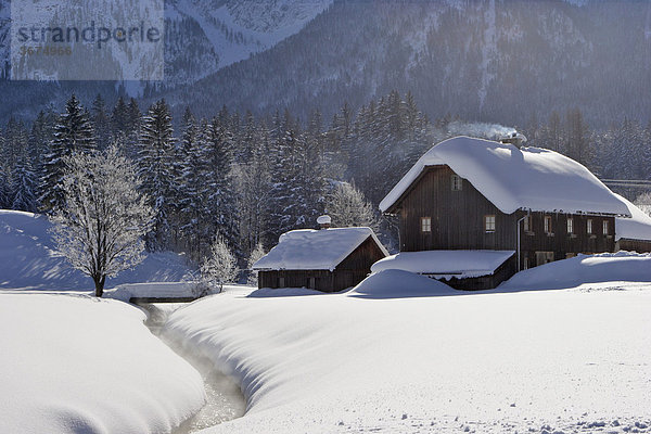 Altes Holzhaus an einem Bach in der tief verschneiten Landschaft Krungl Steiermark Österreich Holzhaus