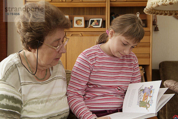 Mädchen liest mit oma