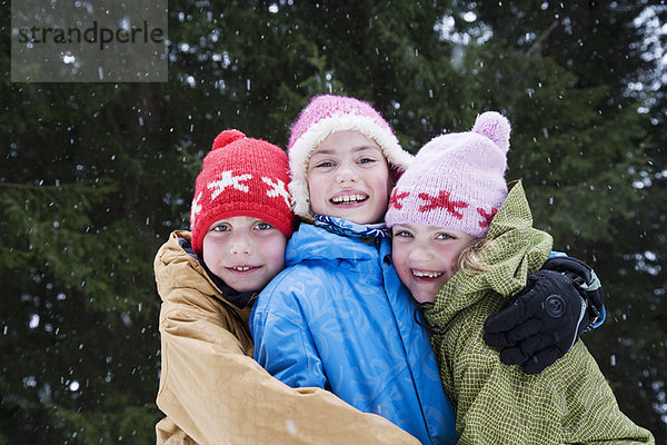 Kinder umarmen sich im Schnee