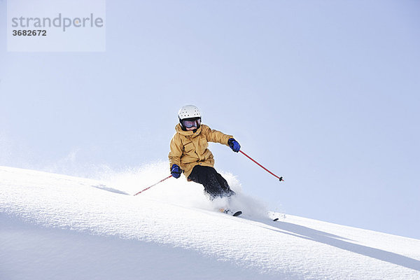 Kleiner Junge beim Skifahren im frischen Pulverschnee